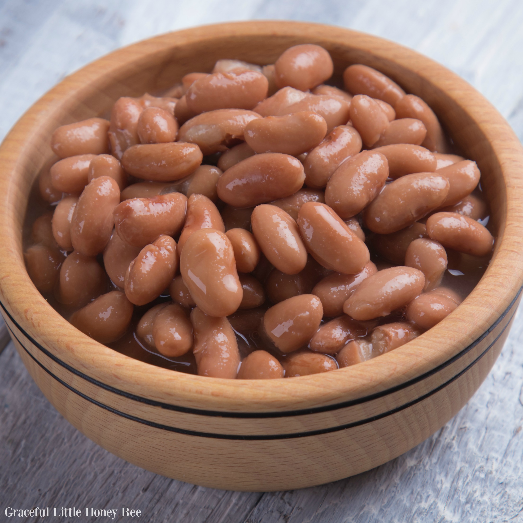 A brown bowl of cooked pinto beans.