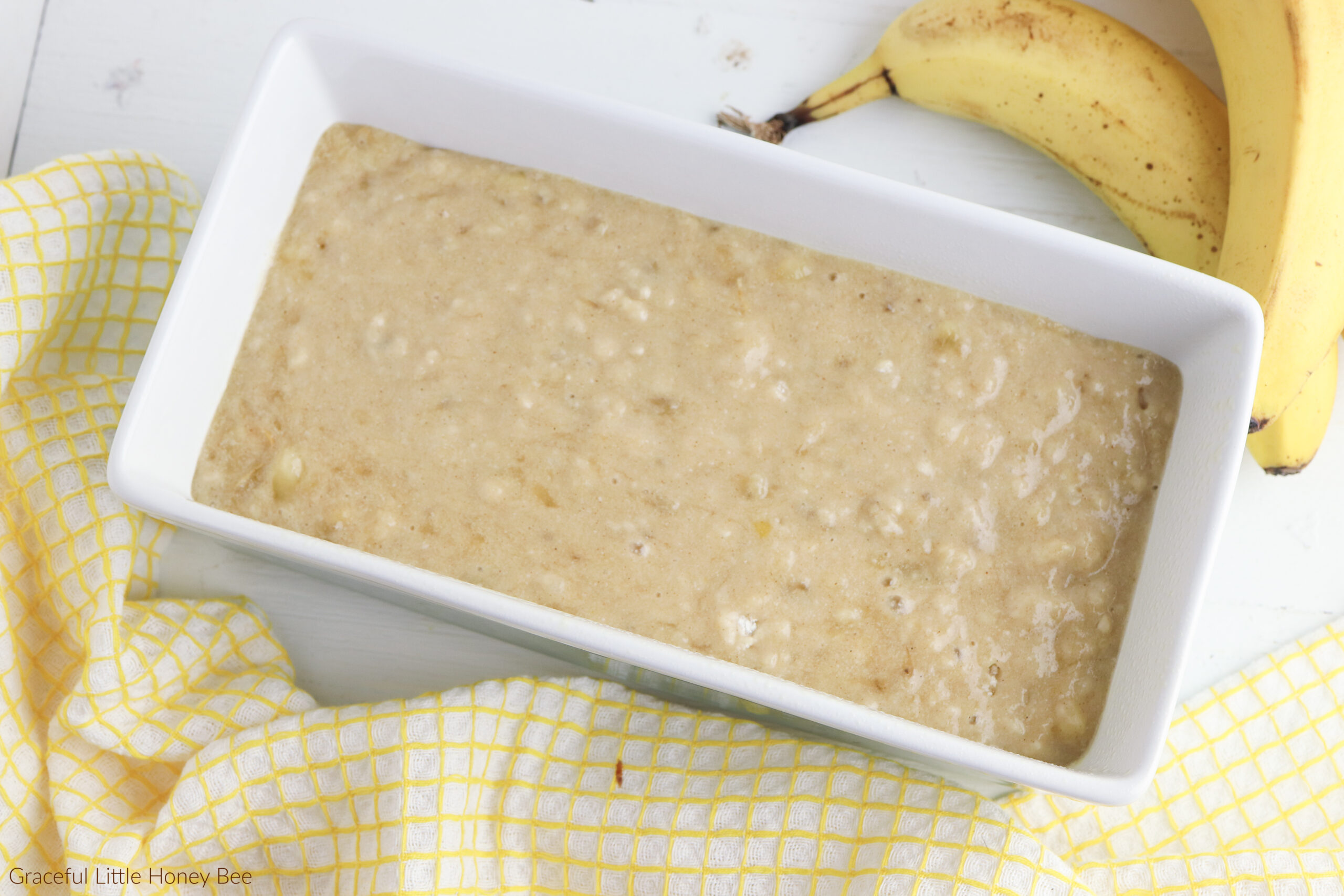 Banana Bread batter in a white loaf pan.