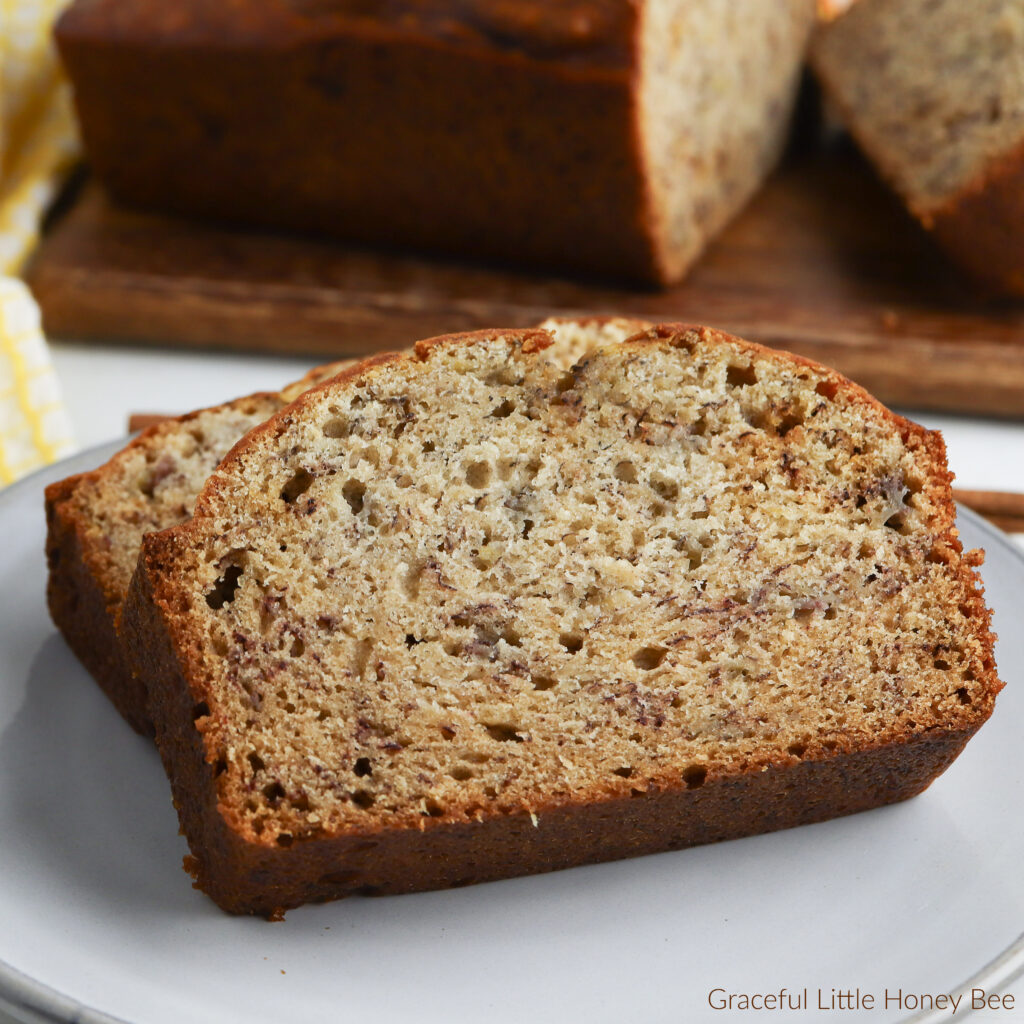 A close up of two slices of banana bread sitting on a white plate.