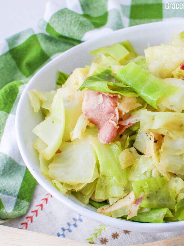 Close up view of fried cabbage with bacon in a white bowl.
