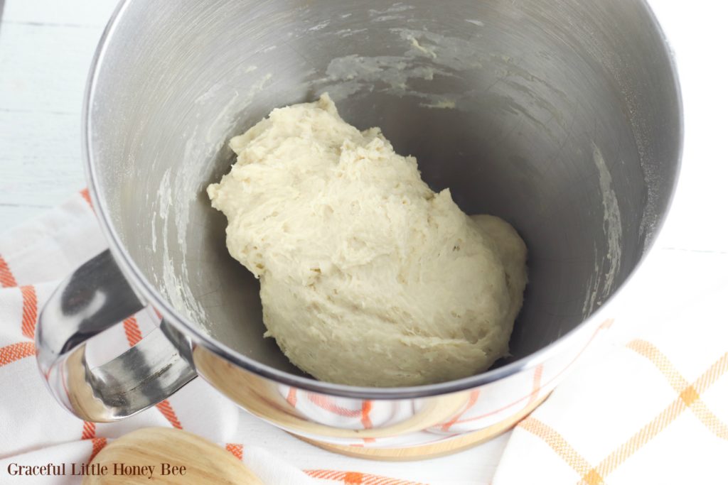 Bread dough in a silver bowl.