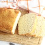 Homemade English Muffin Bread sliced on a wooden cutting board.