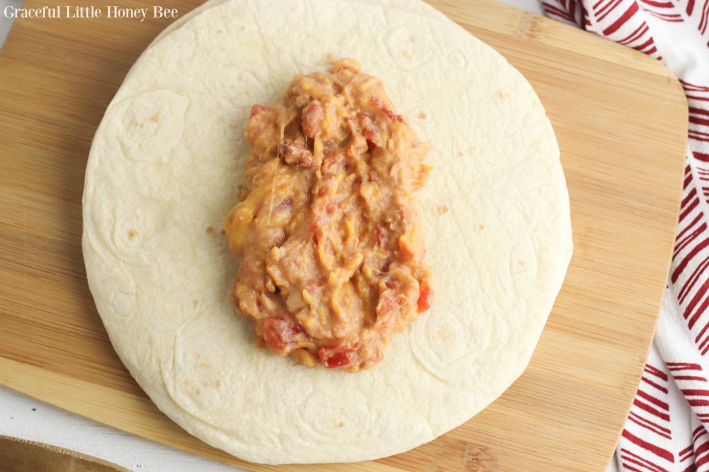 Bean and cheese burrito filling on a tortilla.