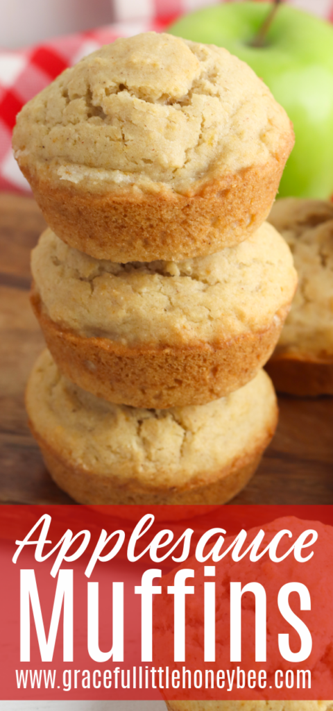 A stack of three muffins sitting on top of on another with a green apple in the background.