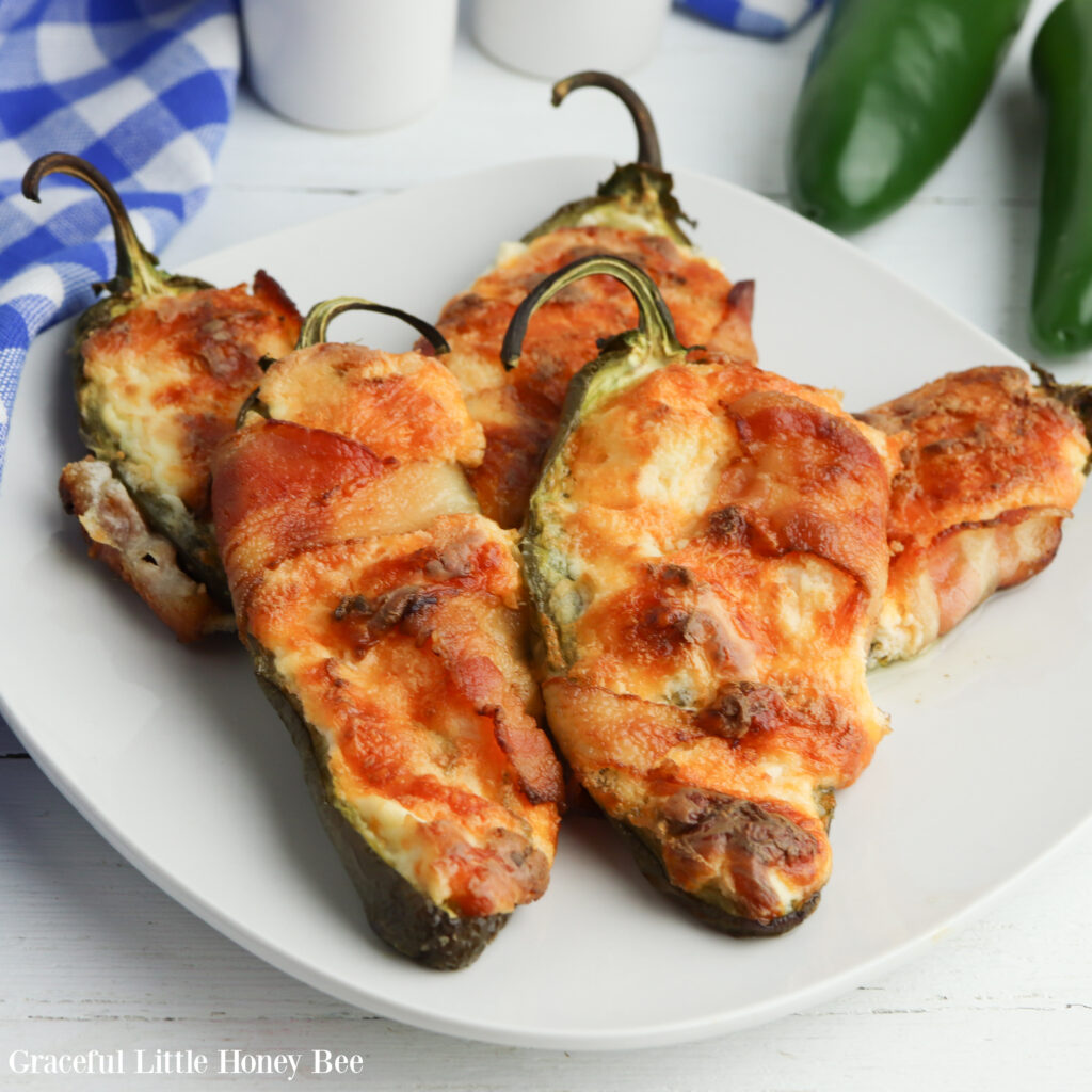 Close up of jalapeno poppers on a white plate.