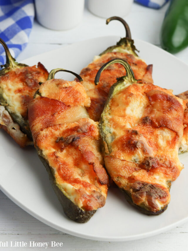 Close up of jalapeno poppers on a white plate.