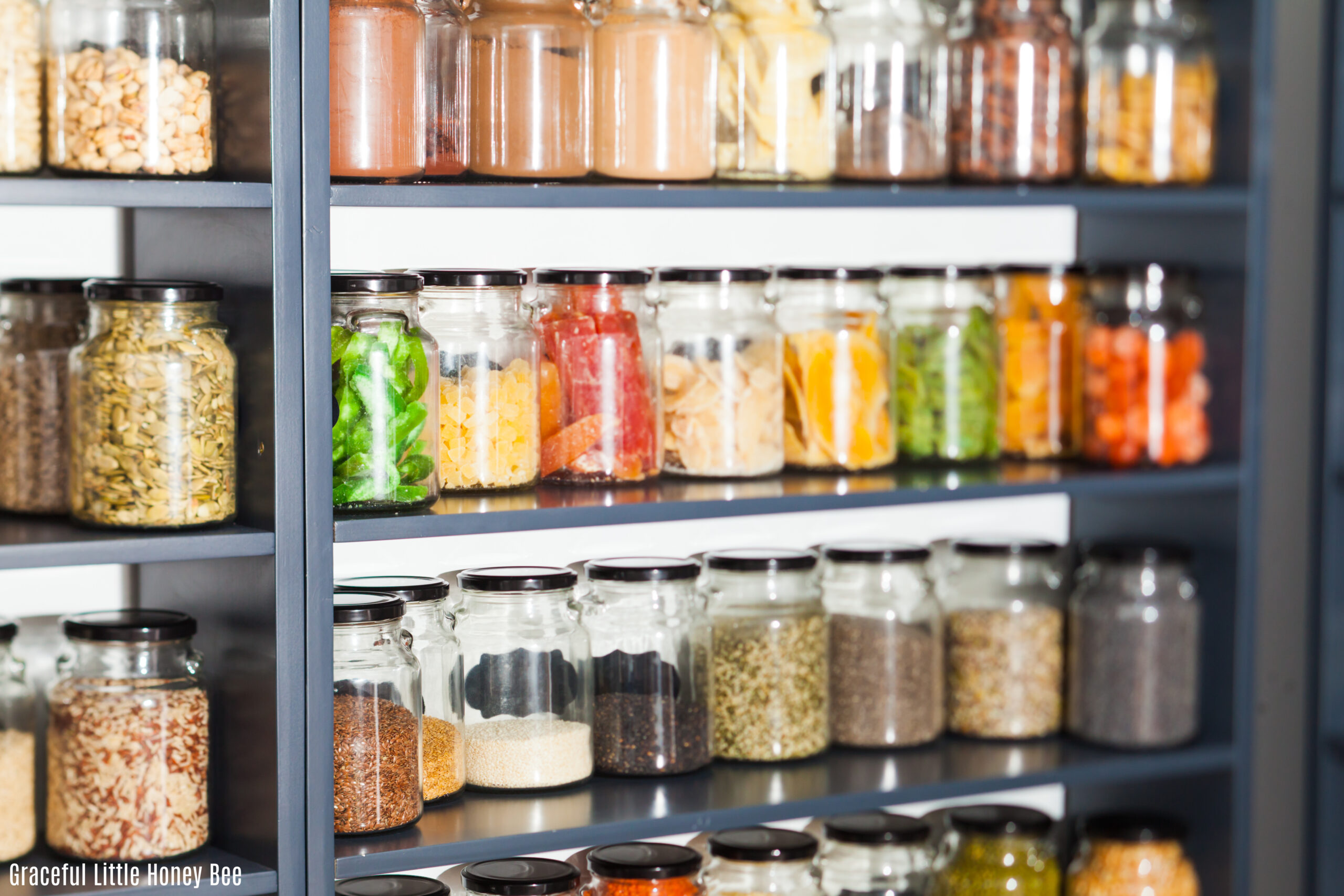 Jars filled with all colors of food sitting on a metal shelf.