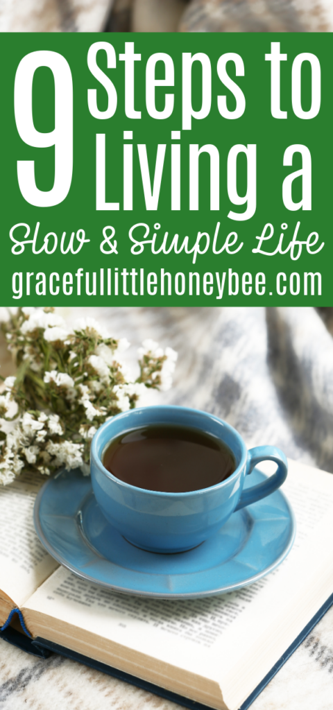 An open book with a blue coffee cup and saucer sitting on top along with a bouquet of baby's breath.