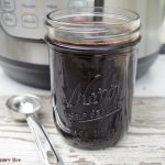 Elderberry syrup in a mason jar with an Instant Pot in the background.