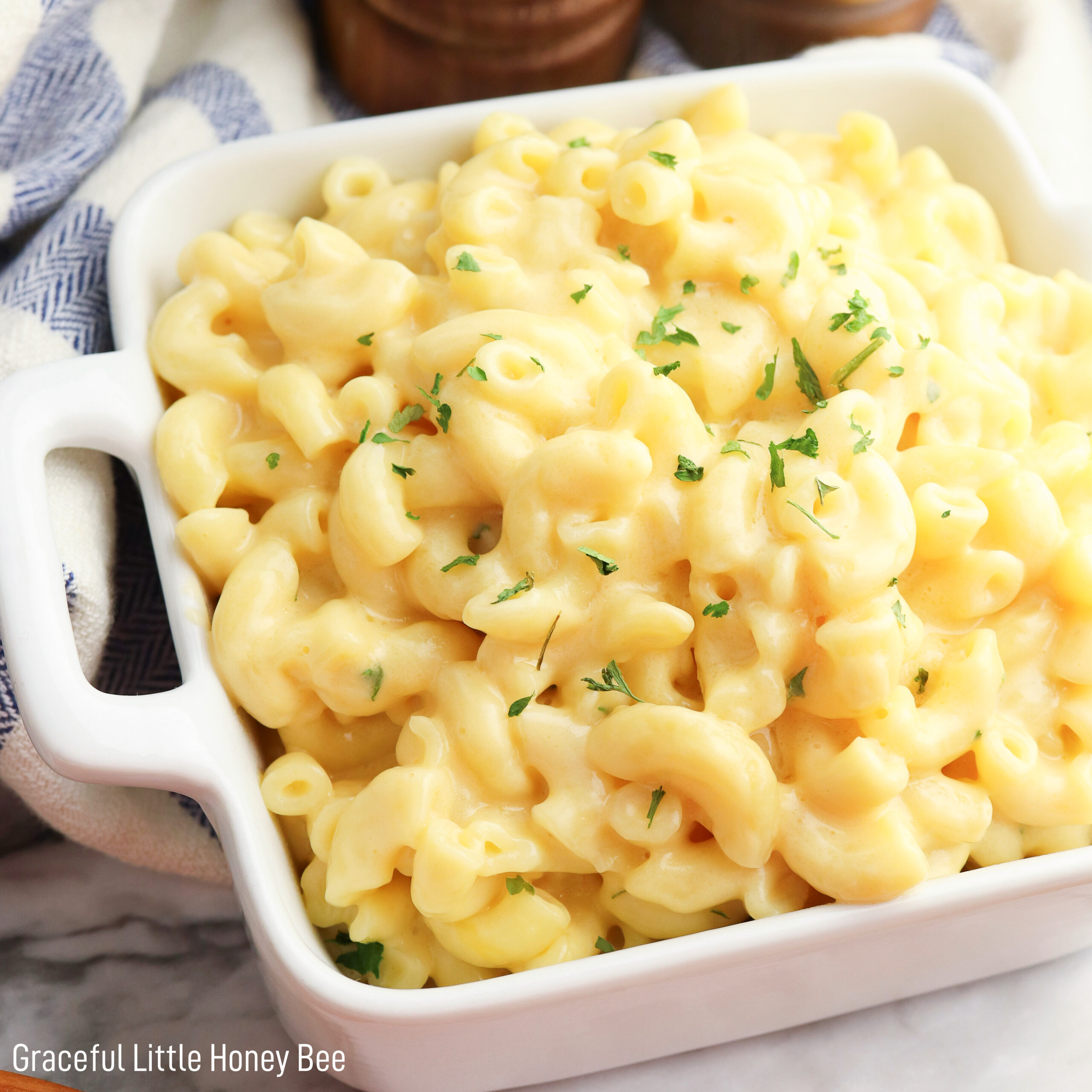 Macaroni and Cheese in a white square dish with a pressure cooker in the background.