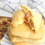 Bacon, Egg and Cheese Breakfast Pockets stacked on a plate.