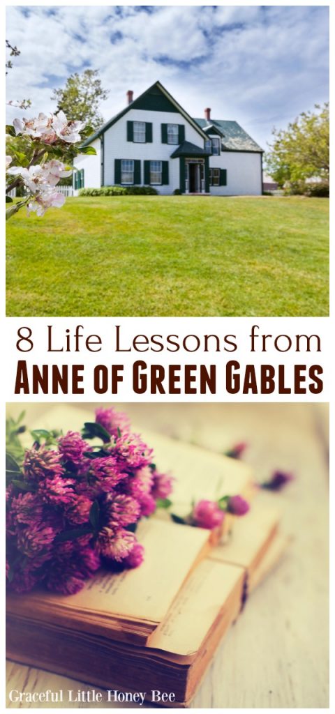 White farmhouse with green gables on a grassy hill.