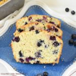 Slices of fresh baked blueberry bread on a blue plate.