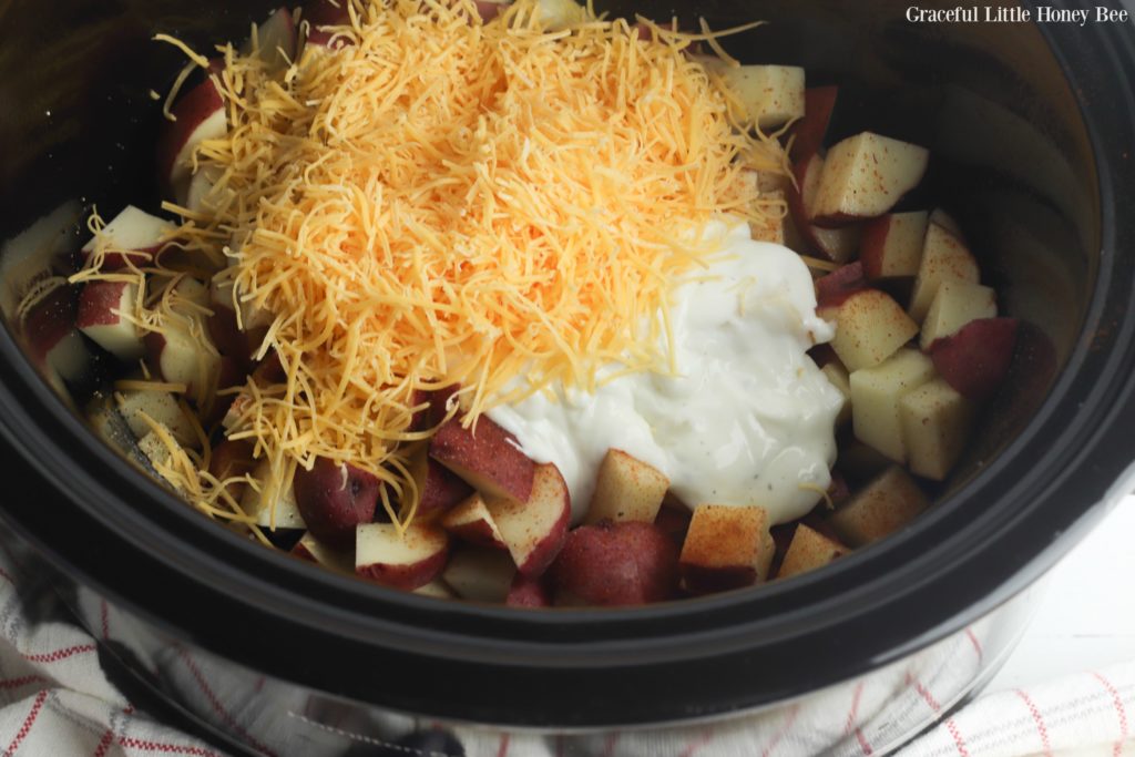 Potaotes, cheese and sour cream in a slow cooker.