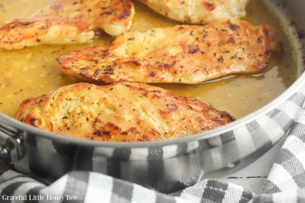 Honey mustard chicken in a stainless steel pan.