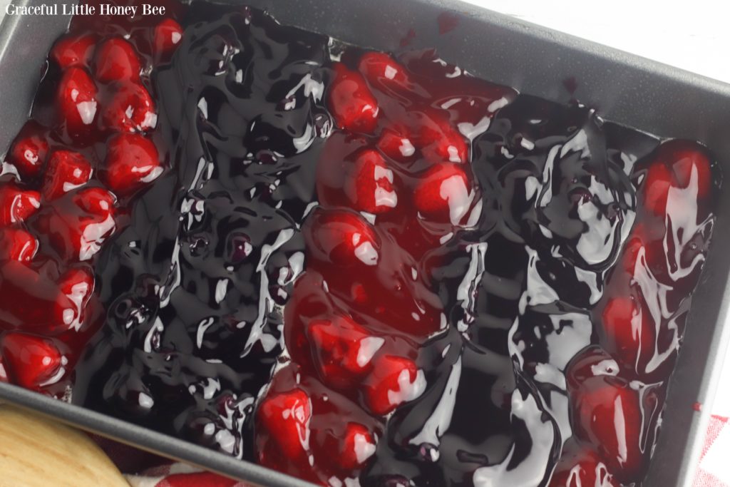 Strawberry and Blueberry Pie Filling alternating in stripes in a baking dish.