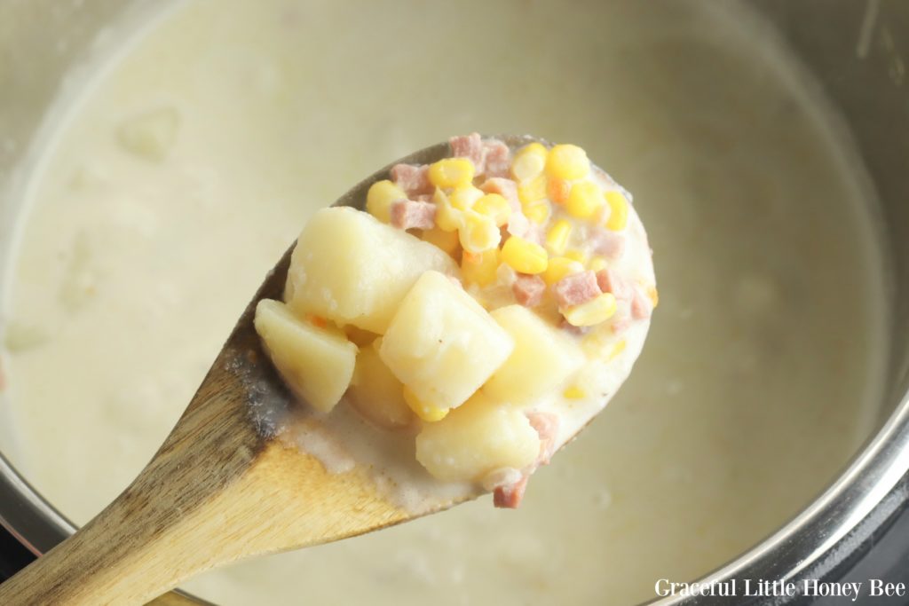 Finished chowder on a wooden spoon above the Instant Pot.