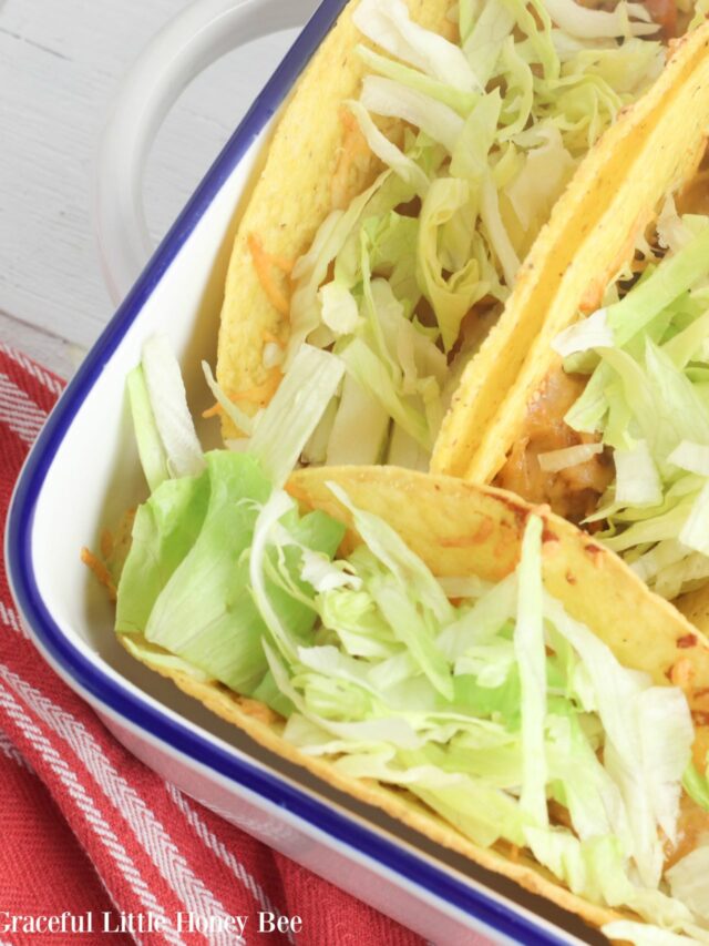 Finished tacos topped with lettuce in baking dish.