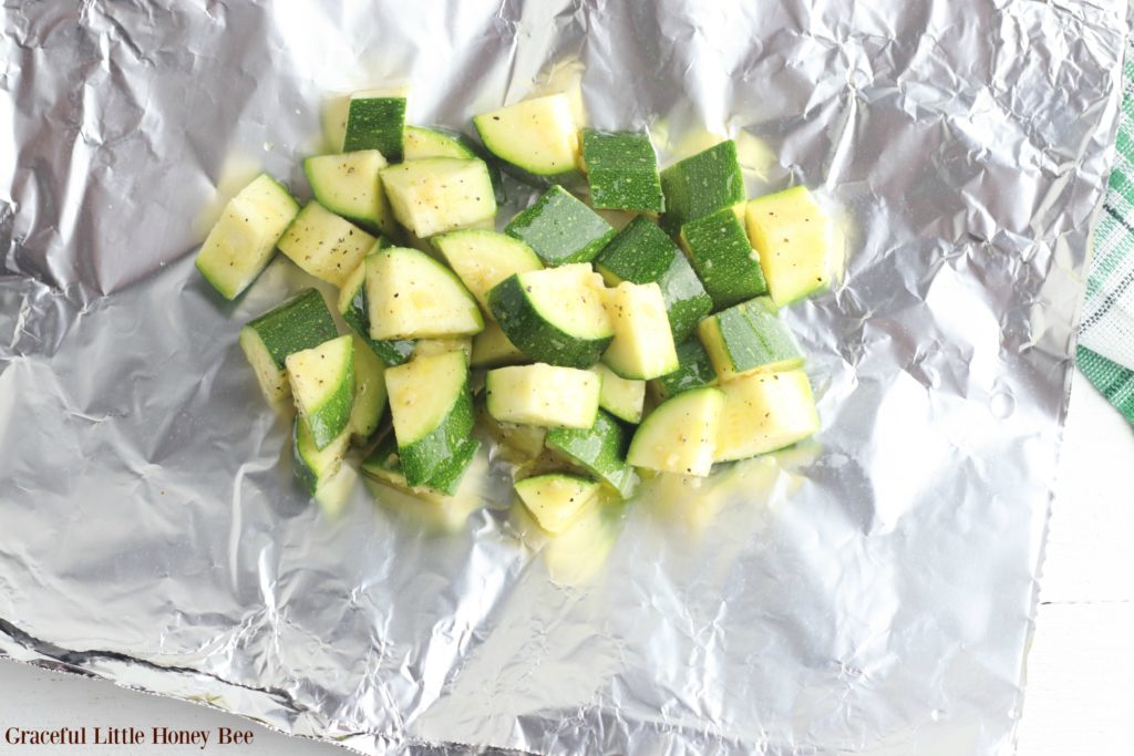 Chopped and seasoned zucchini piled in the center of a piece of foil.