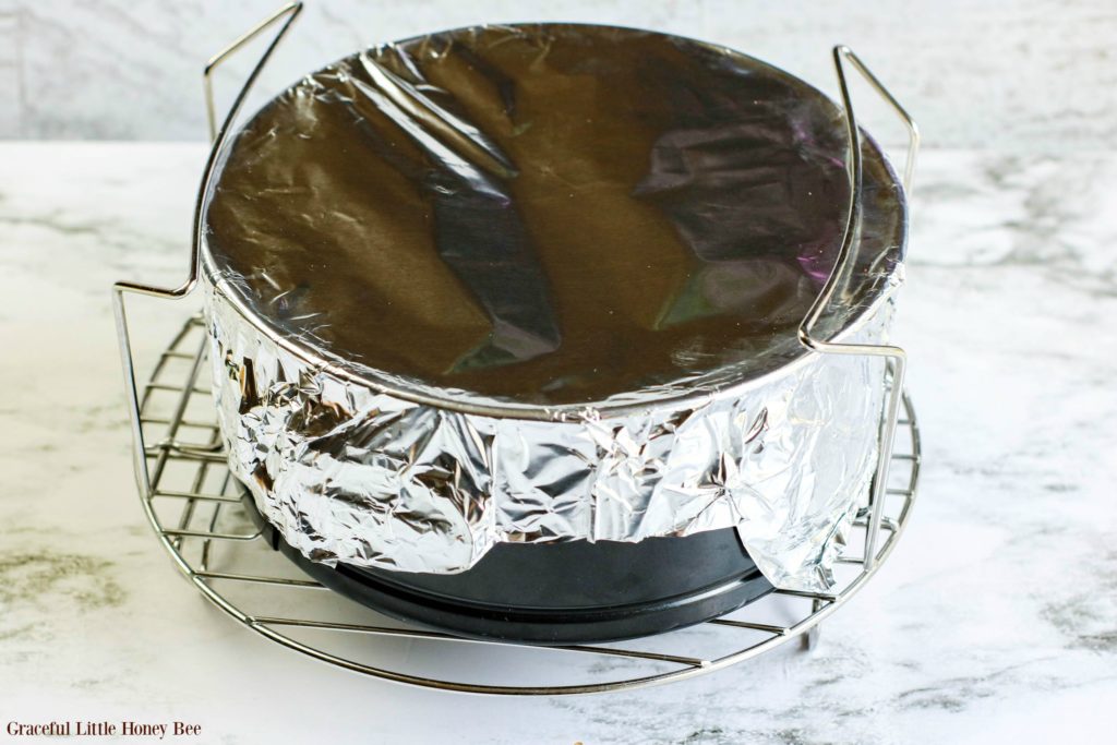 Springform pan covered in foil, sitting on trivet ready to go into the Instant Pot.