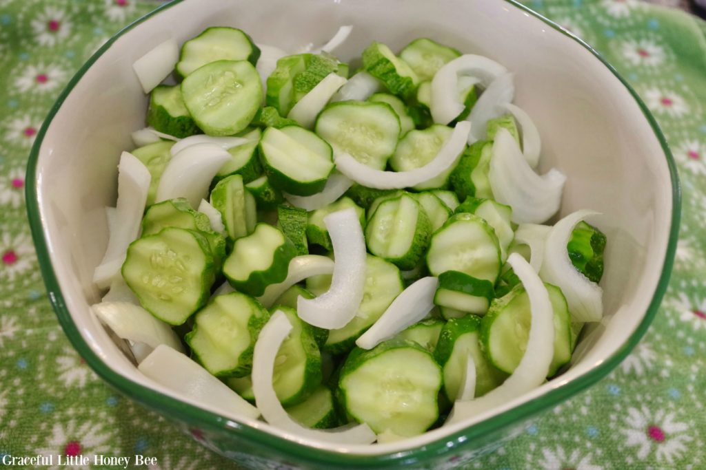 Sliced cucumbers and onions in a bowl.