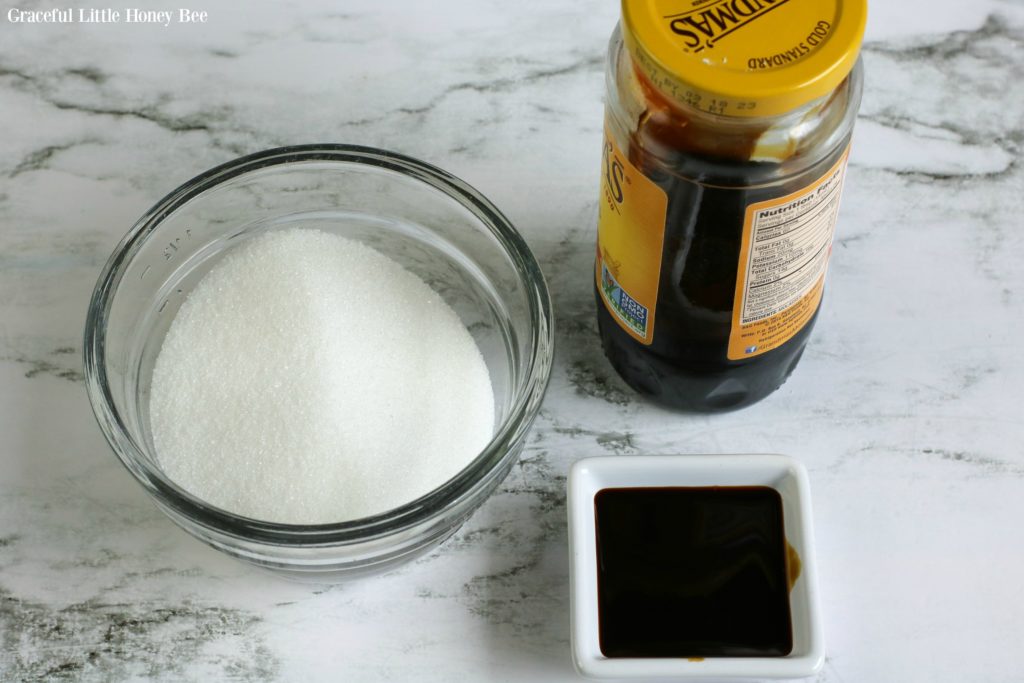 Small bowl of white sugar and a small dish of molasses.