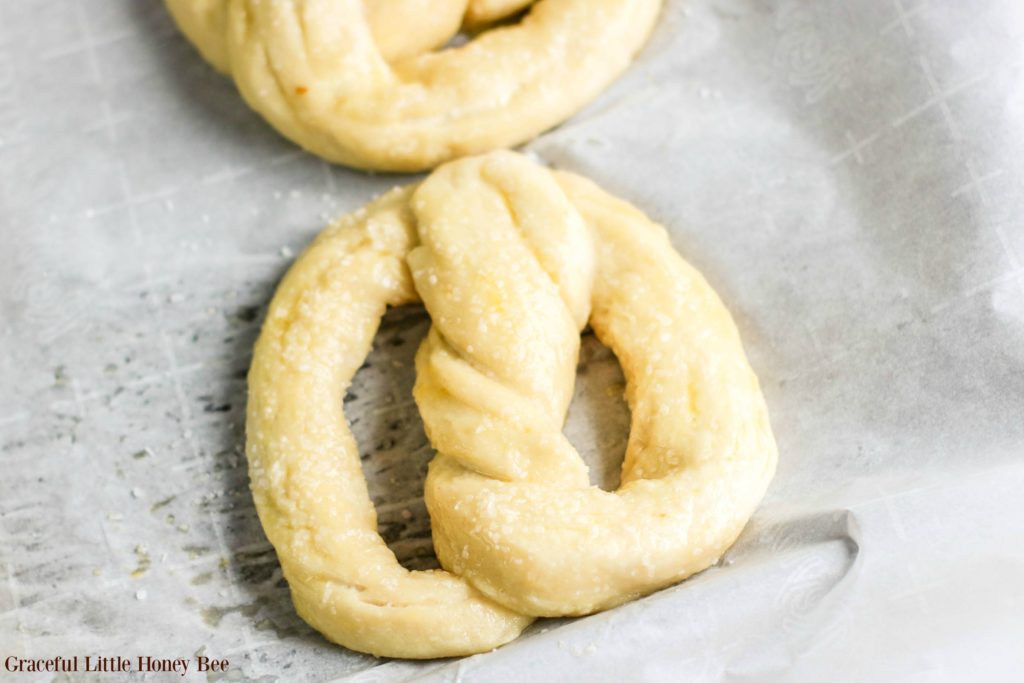 Dough after it has been boiled and salted sitting on a baking tray lined with parchment paper.