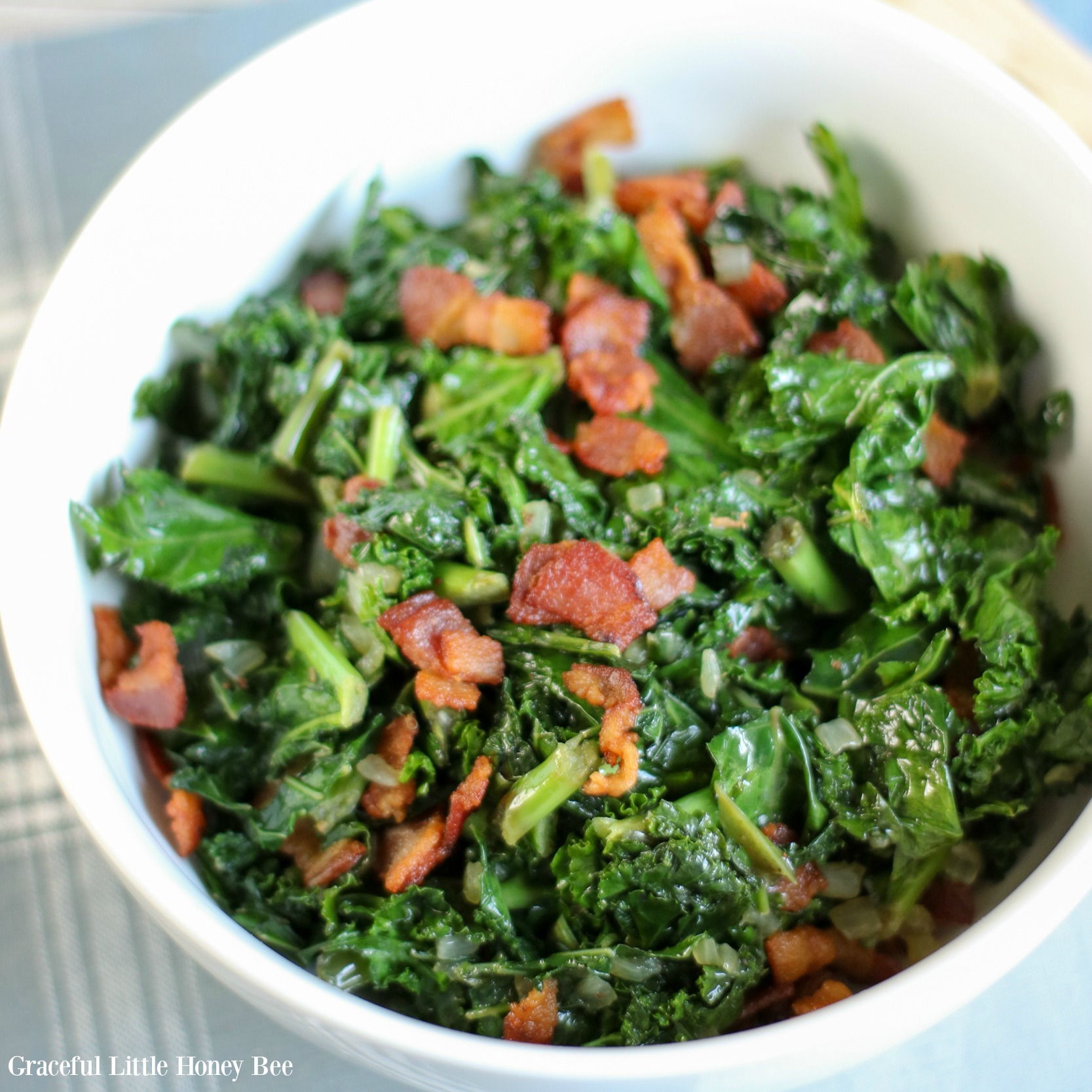 Finished Warm Kale and Bacon Salad in a large white bowl.