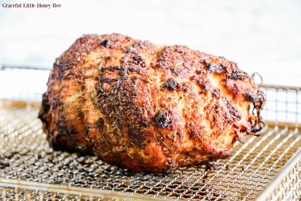 Cooked turkey breast sitting in air fryer basket.