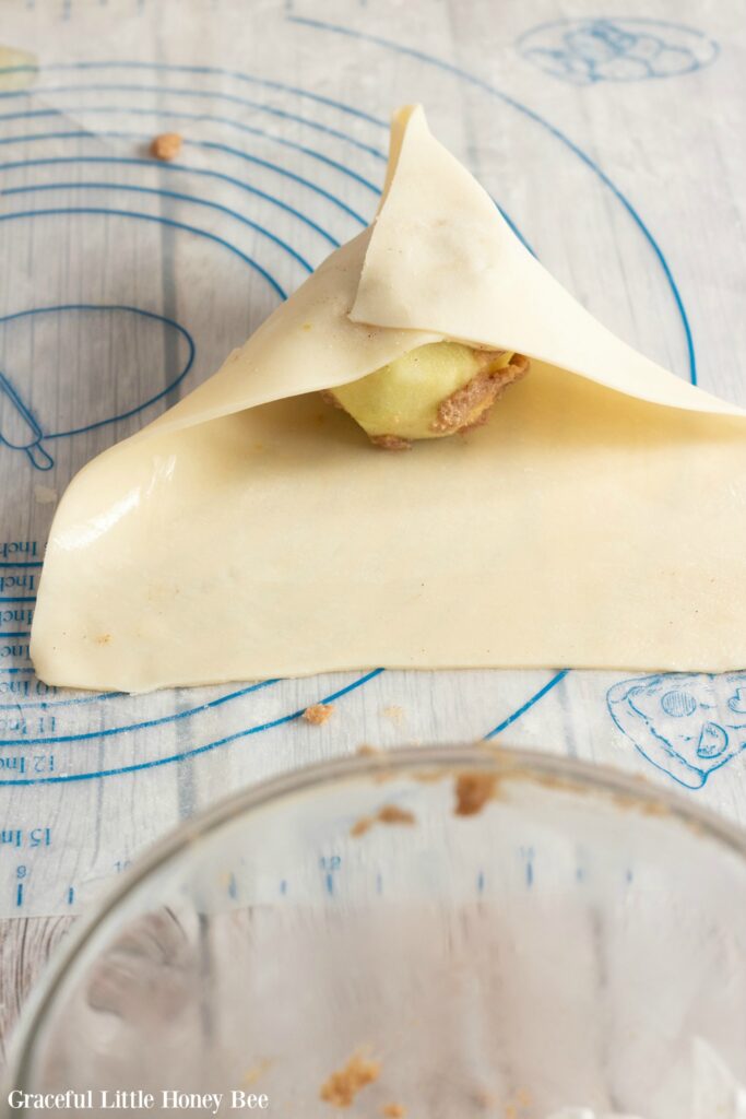 Pie dough folded halfway over onto apple.