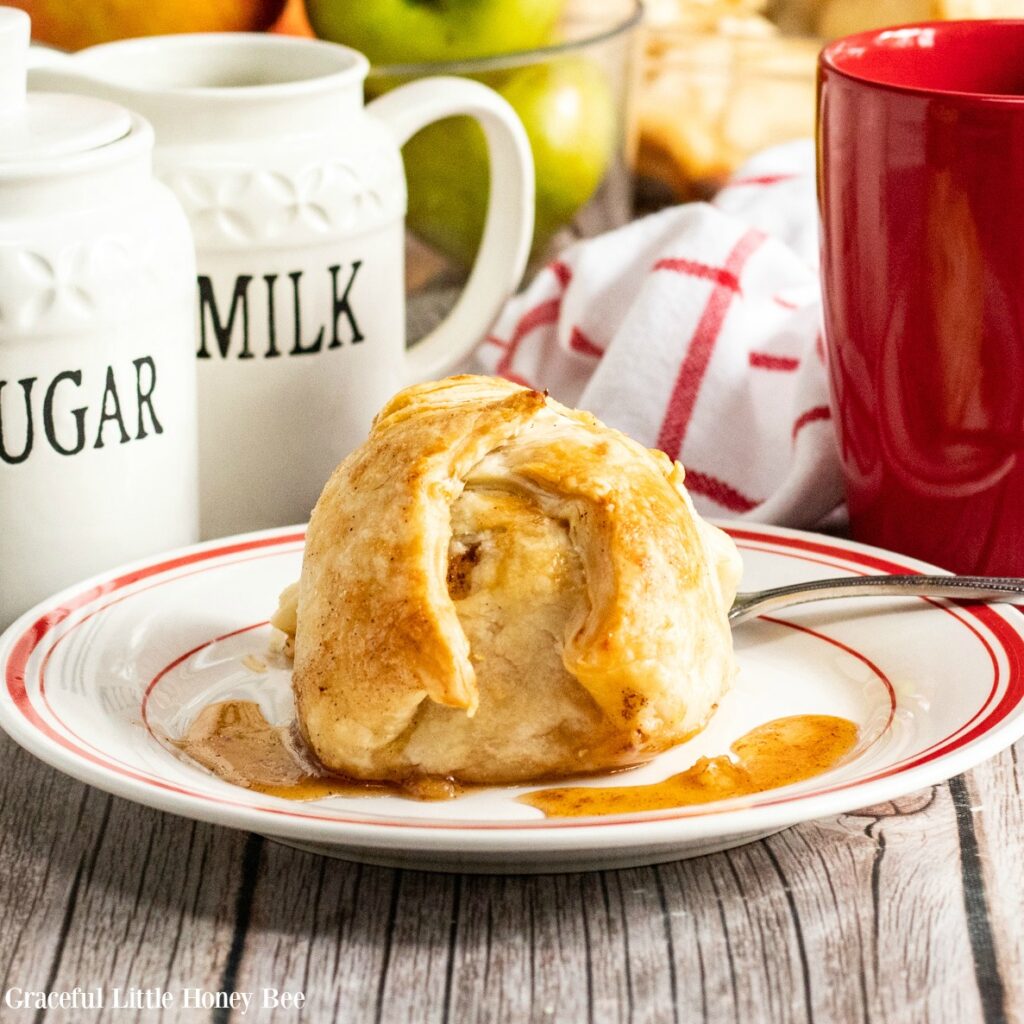 Baked Apple Dumpling drizzled in lemon sauce on a white plate.