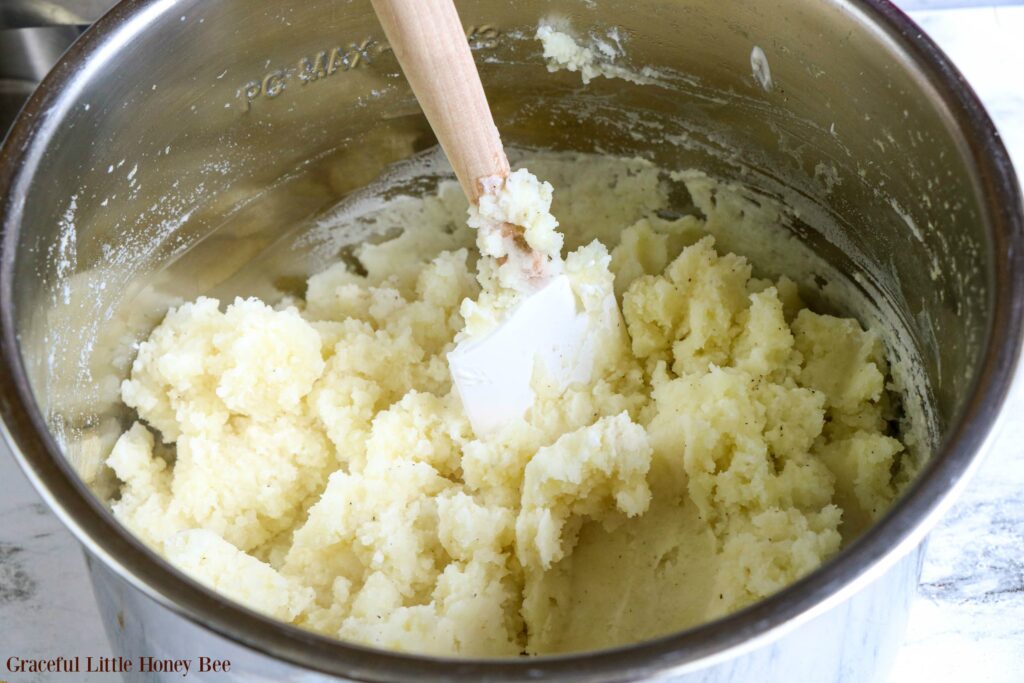 Mashed potatoes in the Instant Pot with a spatula.