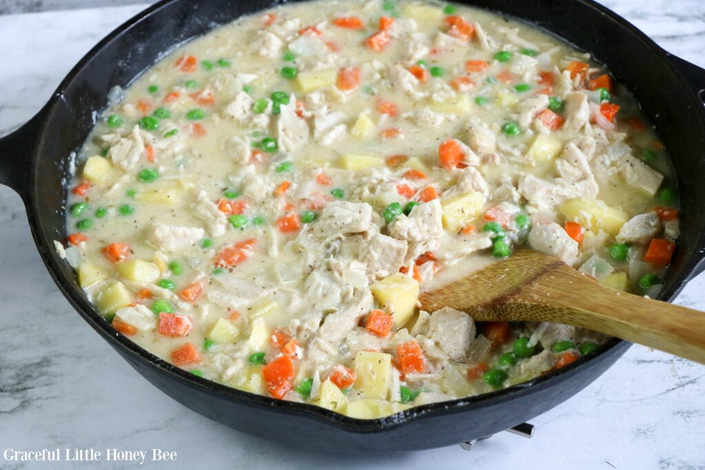 Creamy Turkey Pot Pie filling in a cast iron skillet.