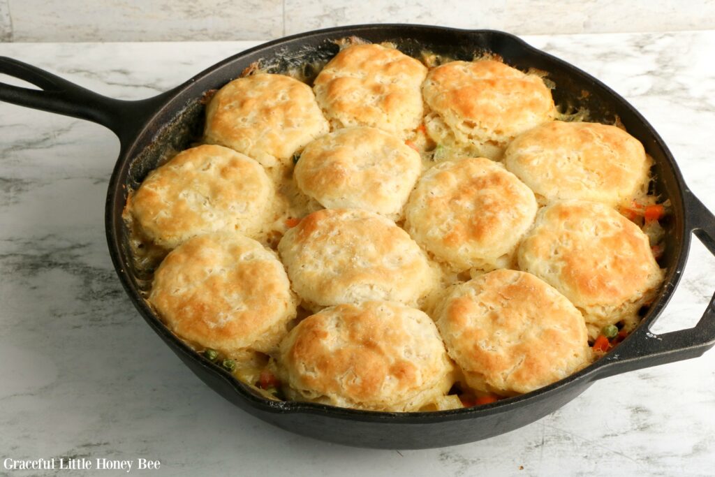 Turkey Pot Pie in a cast iron skillet with a golden brown biscuit topping as the crust.