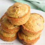 A pile of carrot cake muffins on a white plate.