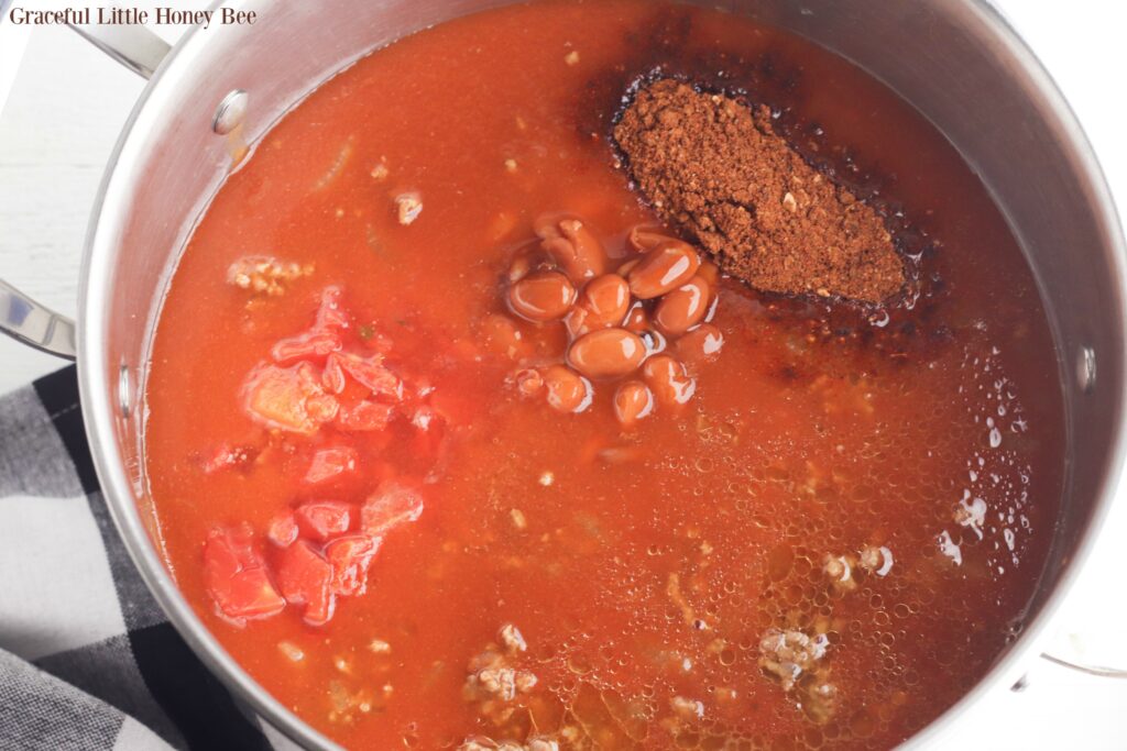 Chili ingredients in a stainless steel pot.