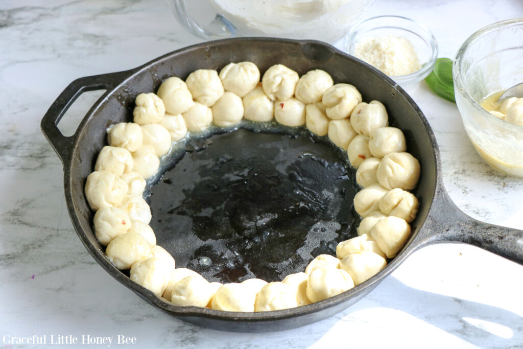 Bread dough dipped in butter layered around the inside perimeter of a cast iron skillet.