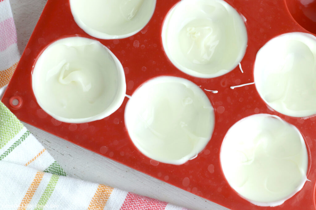 Melted white chocolate in red silicine dome pan.