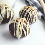 A set of three Mocha Hot Chocolate Bombs sitting on a white countertop.