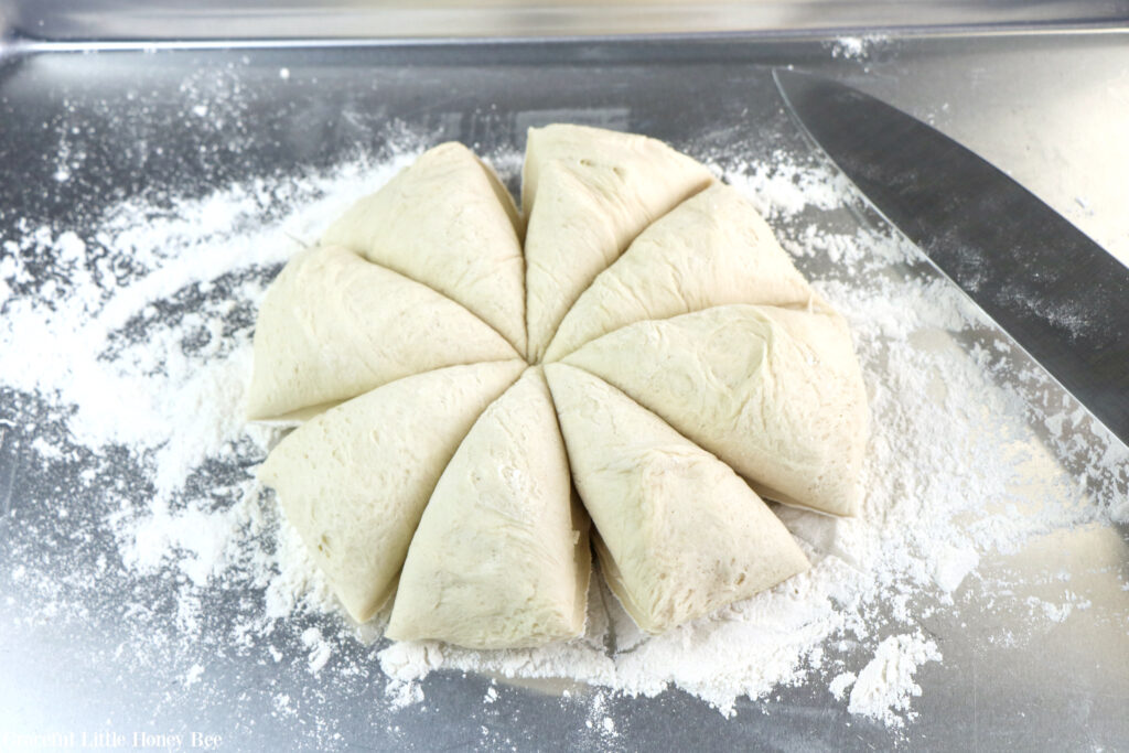 Pretzel dough cut into eight equal parts sitting on a floured countertop.