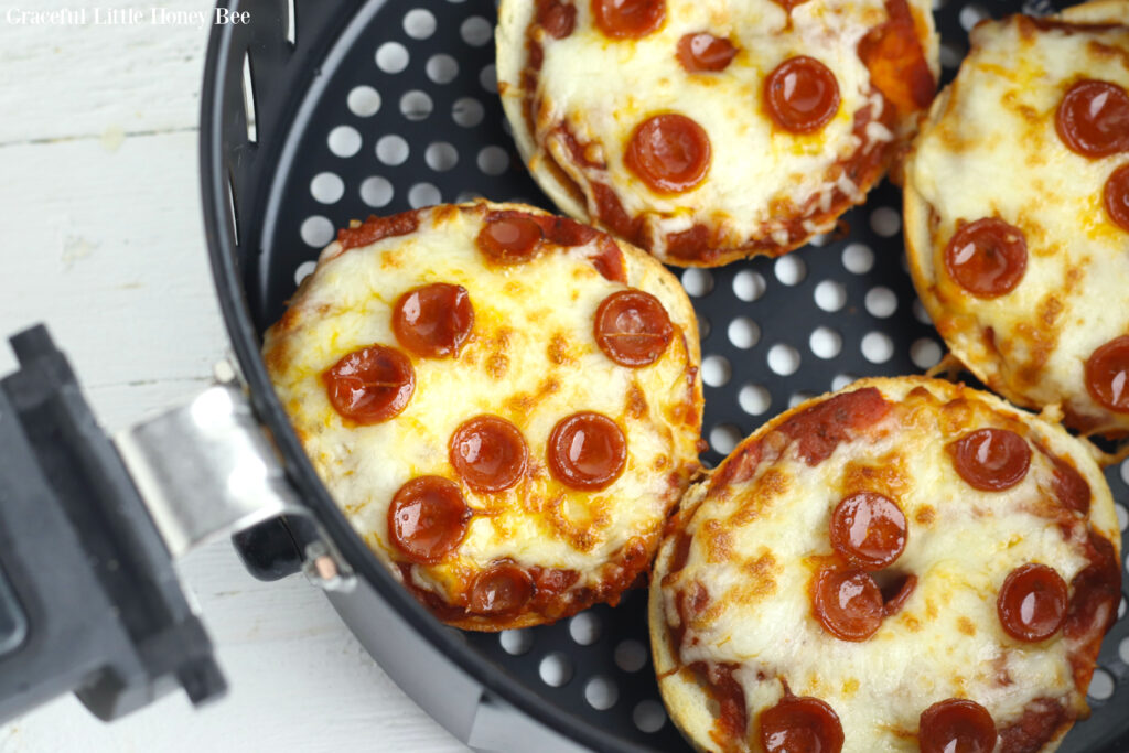 Four Pizza Bagels in the air fryer basket.