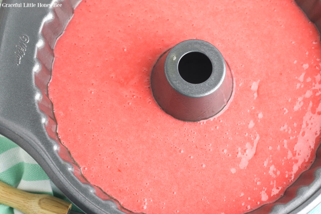 Pink cake batter in a bundt pan before going into the oven.