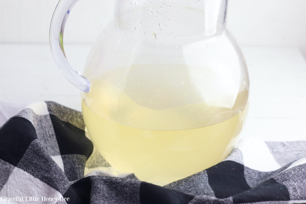 Lemon basil syrup in a clear glass pitcher before adding the club soda.