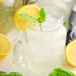 A mason jar full of Basil Sparkling Lemonade garnished with basil and a lemon slice.