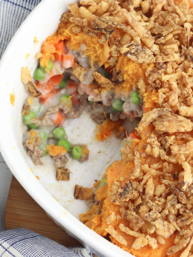 Shepherds Pie in a white baking dish with a serving scooped out.