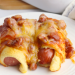 A serving of Chili Cheese Dog Casserole on a small white plate.