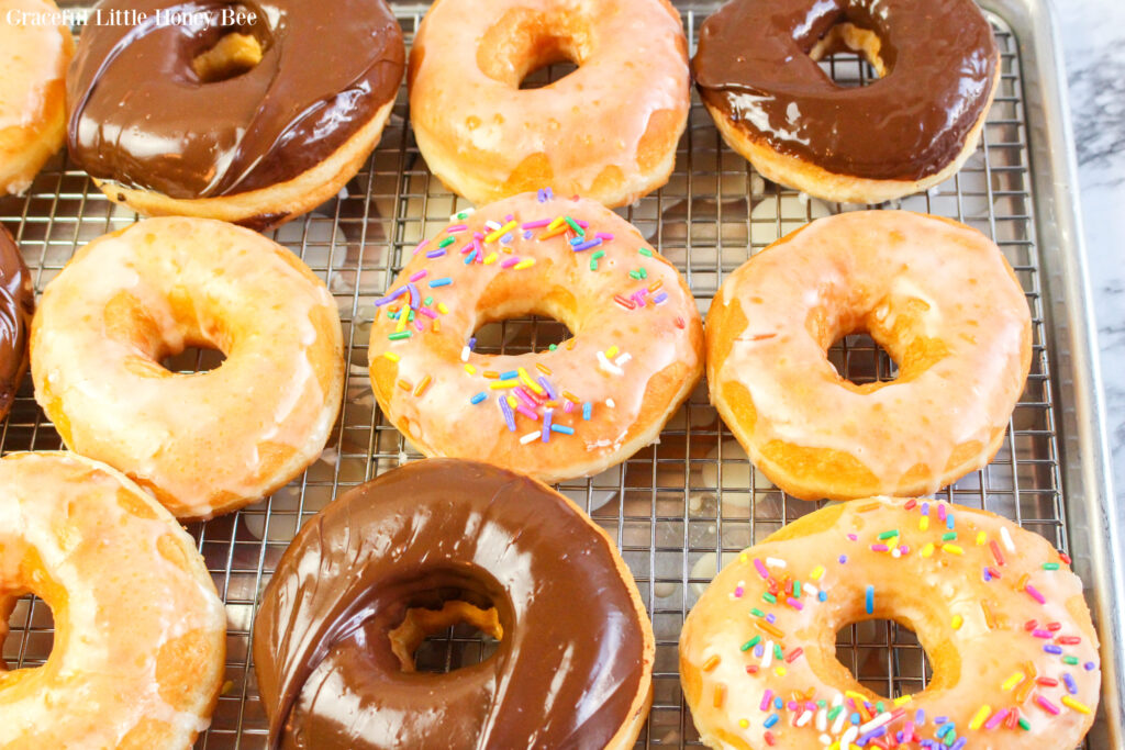 Glazed donuts sitting on a cooling rack.