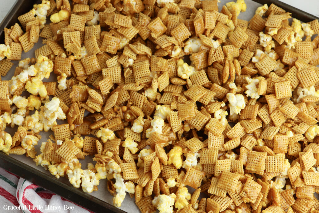 Glazed chex and popcorn on the baking sheet.