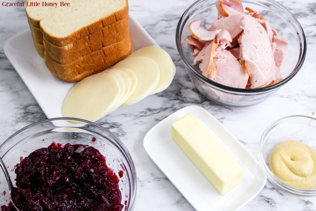 All of the ingredients for Turkey Cranberry Grilled Cheese sitting on a marble countertop.