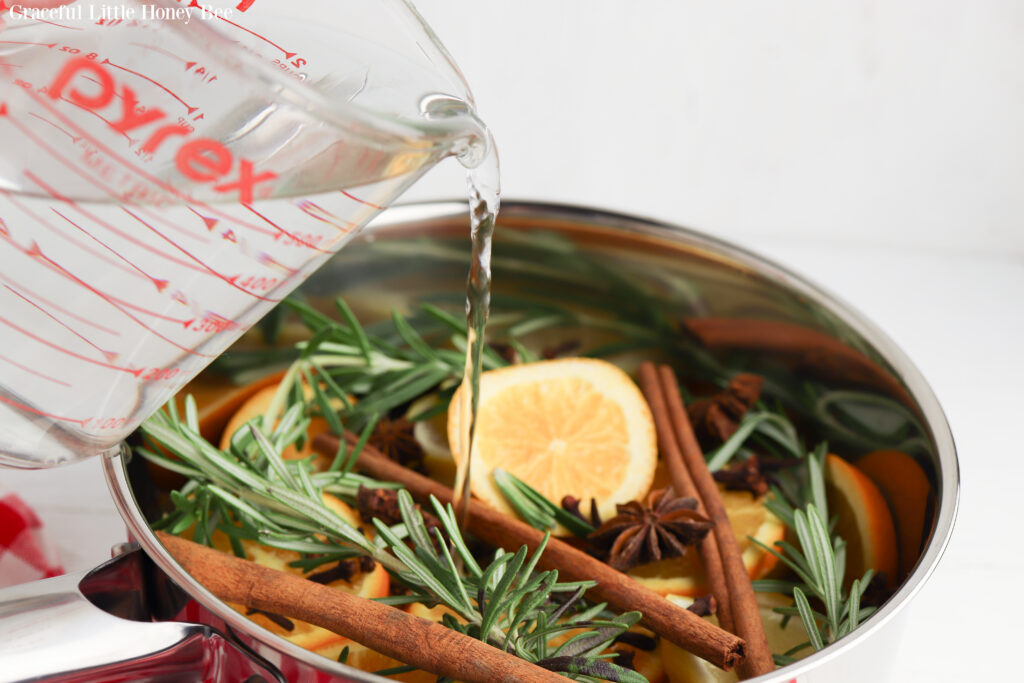 A close up of the stockpot with water being poured into it.